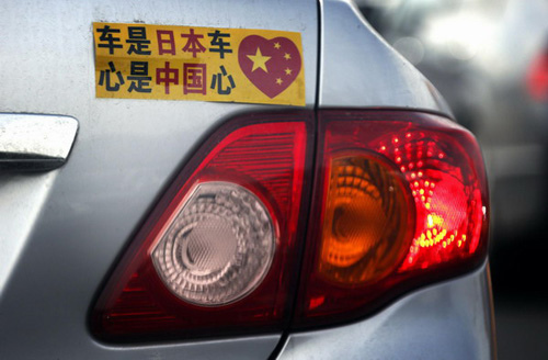 A Toyota car with a sticker attached to the rear can be seen along a main road in central Beijing October 16, 2012. A Toyota Motor Corp spokesman said last week that sales in China fell 48.9 percent in September from a year earlier, while Honda Motor Co reported its sales in China fell 40.5 percent. Japanese car makers reported tumbling sales in China for September, confirming the impact of a territorial row between the two countries and raising concerns that their market share in the world's biggest auto market will continue to shrink. The sticker reads, Japanese car, Chinese heart. [Photo/Agencies]