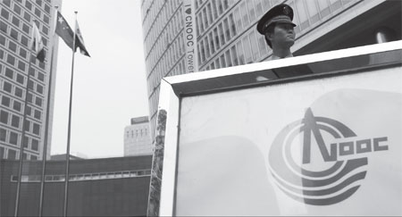 The Chinese national flag flies outside the Cnooc Ltd headquarters in Beijing. More mainland big companies like Cnooc are taking cautious attitude towards M&A in the coming year, according to an Ernst & Young survey. Nelson Ching / Bloomberg