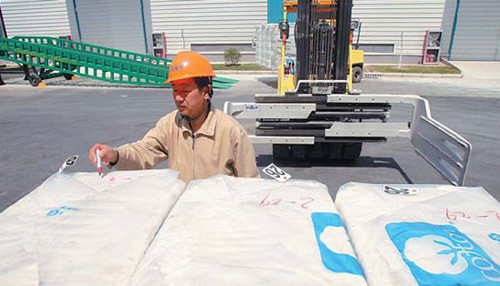 A worker inspects cotton imports at a cotton reserve site in Nantong, Jiangsu province. [Photo/China Daily] 