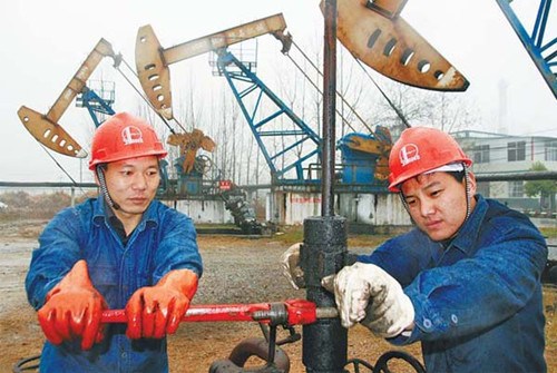 Workers from the Jinglou oilfield in Henan province tighten an oil brake on March 22. In the fourth quarter, China is expected to use 9.64 million barrels of oil a day as the country's economic growth picks up. [Photo/China Daily]