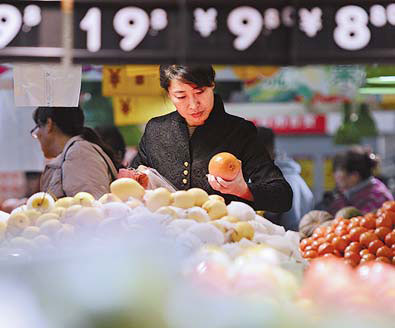 A customer checks fruit at a supermarket in Yichuan, the Ningxia Hui autonomous region, On Friday. Ample food supplies helped inflation ease to a 33-month low.[Photo/Xinhua]