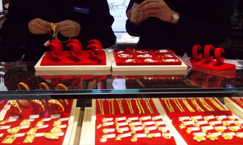 Two shop assistants prepare a gold bracelet display at a jewelry store in Shaoxing, Zhejiang Province, Tuesday. Photo: CFP 