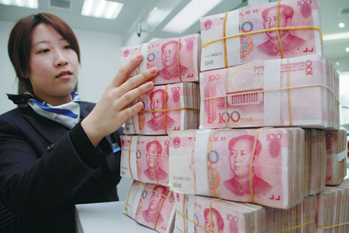 A worker stacks bundles of yuan banknotes at a bank branch in Nantong, Jiangsu province. A Standard Chartered survey has found that 76 percent of multinationals and companies in 16 markets are either already conducting business in yuan, or considering doi