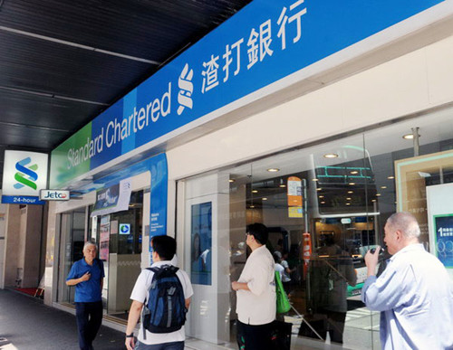 Citizens pass by a Standard Chartered bank in Hong Kong, Aug 15, 2012. [Photo/Xinhua] 