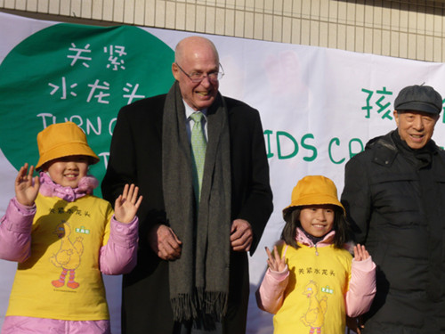 Former US treasury secretary Henry Paulson meets children at a water-conservation event in Beijing in early December. [Photo/China Daily]