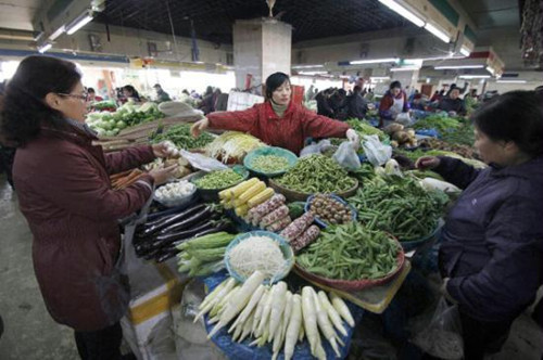 Consumers buy vegetable at a market in Nanjing, capital of east China's Jiangsu Province, Dec. 9, 2012. China's consumer price index (CPI), a main gauge of inflation, grew 2 percent year on year in November, the National Bureau of Statistics announced Sunday. The inflation rate increased from a 33-month low of 1.7 percent in October as food prices increased. (Xinhua/Dong Jinlin)  