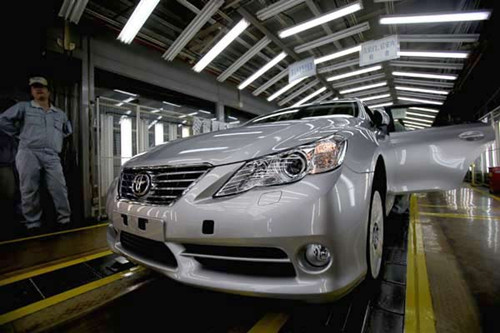 A worker stands next to a Toyota Motor Corp vehicle at the company's assembly line in Tianjin. According to a report on Sunday by the Japanese newspaper Asahi Shimbun, the future of Toyota's fourth factory in Tianjin will hinge on the recovery of sales in China. Provided to China Daily 