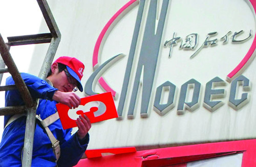 Workers update a sign displaying gasoline and diesel prices at a Sinopec gas station in Yichang, Hubei province. [Photo/China Daily] 