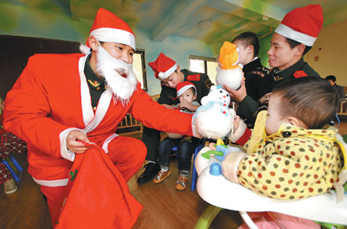 Soldiers don a different uniform as they bring joy to orphans in Taizhou, Zhejiang province, on Christmas Eve. Jia Ce/For China Daily