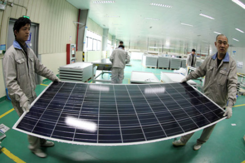 Workers carry a solar panel at a production plant in Ganyu county in Jiangsu province. China plans to install 2.83 gigawatts of solar production in its latest batch of solar-energy projects. [Photo/China Daily]   