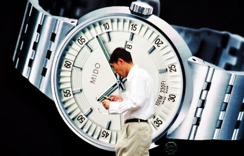 A pedestrian walks by a Swiss watch advertisement in downtown Shanghai in September 2011. Jing Wei / for China Daily