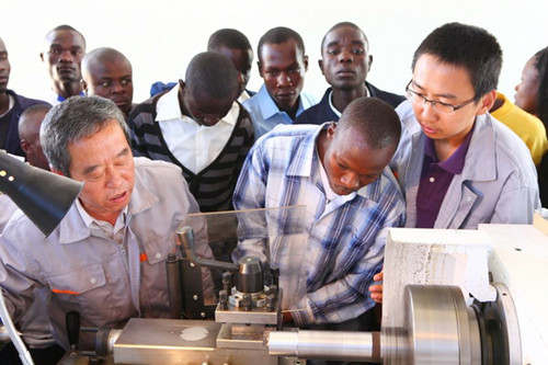 Two Chinese instructors provide training on machinery operation to students at a university in Kenya. [Photo / China Daily]