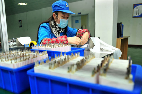 A worker assembles environmentally friendly lithium batteries at an industrial park in Yichang, Hubei province. A survey found that China retains fi rst place in terms of competitiveness in manufacturing, followed by Germany and the United States. [ZHANG GUORONG / FOR CHINA DAILY]