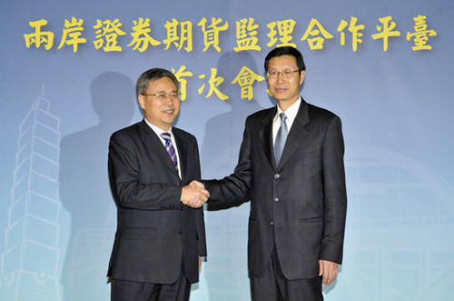 Guo Shuqing (left), chairman of the China Securities Regulatory Commission, shakes hands with Chen Yuh-chang, chairman of the Financial Supervisory Commission, in Taipei on Tuesday. The mainland will open its securities and futures markets to Taiwan investors through the Renminbi Qualifi ed Foreign Institutional Investor program. [CHEN ZHENTANG / FOR CHINA DAILY]