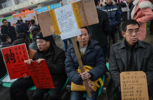 Recruiters hold employment boards at a job fair in Yiwu, east China's Zhejiang Province, Feb. 17, 2013. (Xinhua/Han Chuanhao)