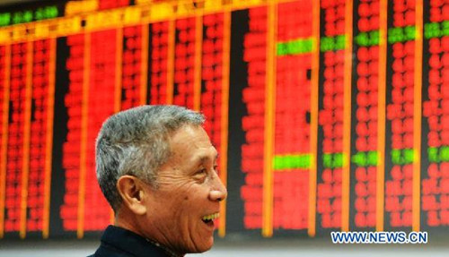 An investor smiles in front of an electronic board showing stock price rise in a trading hall of securities firm in Hangzhou, east China's Zhejiang Province, Feb. 28, 2013.(Xinhua)