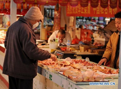 A customer purchases chicken at a market in Changchun, capital of northeast China's Jilin Province, March 9, 2013. China's consumer price index (CPI), a main gauge of inflation, grew 3.2 percent year on year in February, the highest level in ten months, the National Bureau of Statistics announced Saturday. (Xinhua/Zhang Nan)