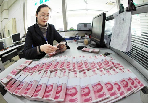 A clerk counts banknotes at a rural bank in Ganyu, Lianyungang city in Jiangsu province. A report by HSBC said China is likely to further widen the yuan's daily trading band and change the currency's fixing mechanism against the US dollar this year. [Photo/China Daily]