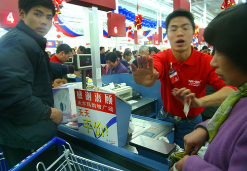 An employee of Wal-Mart Stores Inc asking a man not to take a photo at a Wal-Mart outlet in Nanjing, capital city of East Chinas Jiangsu province. Wal-Mart said in March that it will close two stores in April after a business appraisal. One is in Wuxi city and the other is in the city where it has its China headquarters  Shenzhen. AN XIN / FOR CHINA DAILY