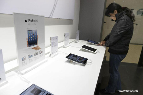 A customer tries on Apple's iPad mini, at an authorized store in Wuhan, capital of central China's Hubei Province, Dec. 7, 2012. Apple's iPad mini and the fourth-generation iPad went on the Chinese mainland market on Friday. (Xinhua)