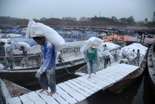 Workers unloading goods imported from Vietnam at a dock in Dongxing city, South China's Guangxi Zhuang autonomous region. Around 75 percent of respondents expect wages to increase by as much as 10 percent this year, similar to 2012, said Standard Chartered in its latest report. [Provided to China Daily]