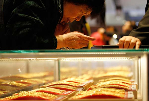 A senior citizen examining gold necklaces at a department store in Nanjing, capital of East Chinas Jiangsu province. Many senior citizens believe that it is an opportune time to buy the yellow metal as prices have plummeted to a historical low in over 30 years. Provided to China Daily