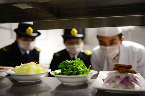 Two uniformed officials inspecting food quality at a restaurant in Qingdao, East China's Shandong province. Business credibility continues to be the top concern for a majority of the private entrepreneurs in China. Yu fangping/for China Daily