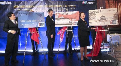 (L-R) Dong Xiaojun, deputy consul general of the Chinese Consulate General in New York, Su Ning, China UnionPay board chairman, and Betsy Cohen, CEO of the Bancorp Bank, unveil the new cards during the issuing ceremony for the first UnionPay Card in the United States between the Bancorp bank and UnionPay international in New York City, the United States, April 29, 2013. (Xinhua/Cheng Li)