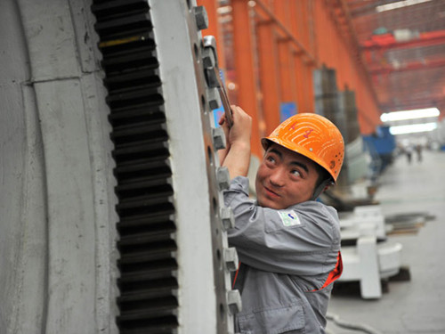 A worker tests wind power equipment in Zouping, Shandong province. Manufacturers have felt increasing pressure since last year, when GDP expanded by 7.8 percent year-on-year, the slowest pace for 13 years. CUI PENGSEN/FOR CHINA DAILY