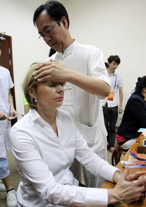 Henriette Reker, deputy mayor of Cologne, Germany, receives traditional Chinese medical therapy at the fair on Wednesday. Zhang Wei/China Daily 