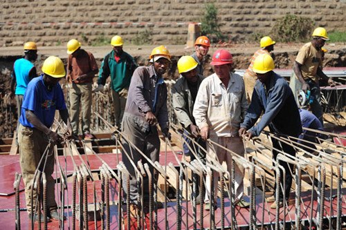 Chinese technicians and African workers at an expressway construction site in Nairobi, Kenya. China has established two funds to finance Chinese enterprises investing in Africa. ZHAO YINGQUAN/XINHUA