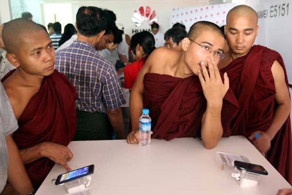 Even monks were not immune to the excitement when Huawei's showroom opened in Yangon, Myanmar. The company's handsets are the most popular in Myanmar, garnering a market share of more than 60 percent. The company plans to open 40 to 60 flagship showrooms in the country this year, offering smartphones and other high-tech products. Zhang Wei/China Daily 