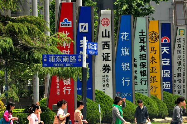 Outdoor ads for foreign and Chinese financial institutions are seen in Shanghai. Chinese companies are investing broadly in industries across the world, according to a United Nations Conference on Trade and Development report. YAN DAMING/FOR CHINA DAILY