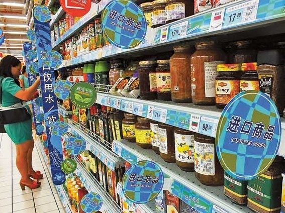 A shopper selects products at an imported goods shelf at a supermarket in Yichang, Hubei province. Liu junfeng/for China Daily  