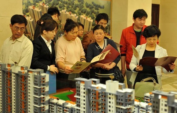 Potential homebuyers look at models of residential property in Zhoushan, Zhejiang province. Provided to China Daily