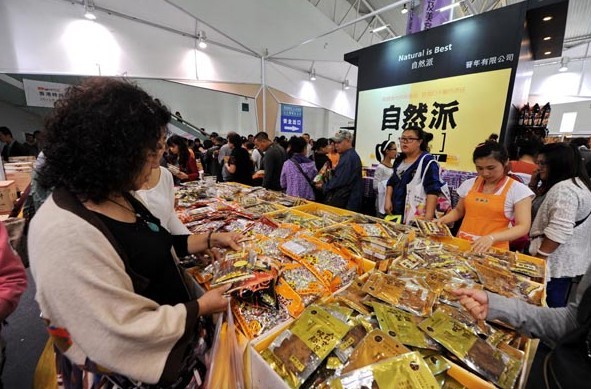 Customers buy snacks at the China-Northeast Asia Expo on Sept 7 in Changchun, Jilin province. The leisure food business has attracted increasing investment in the country. Zhang Nanshe for China Daily  