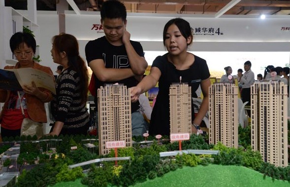 Visitors inspect property models at a housing fair in Changsha in September. [Photo / Provided to China Daily] 