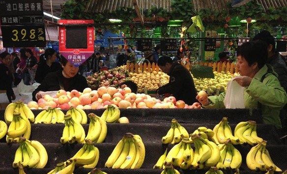 People select fruit in a supermarket in Shanghai, east China, Dec. 8, 2013. China's consumer price index (CPI), a main gauge of inflation, grew 3 percent year on year in November, down from the 3.2 percent recorded in October, the National Bureau of Statistics (NBS) said on Monday. (Xinhua/Yang Shichao)  