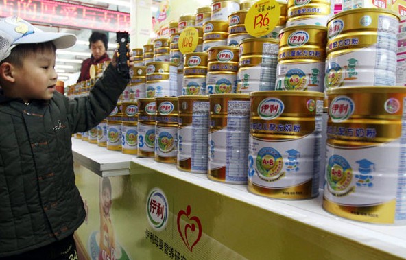 A child helps his parents shop for milk powder in a supermarket in Xuchang, Henan province. [Photo / Provided to China Daily]