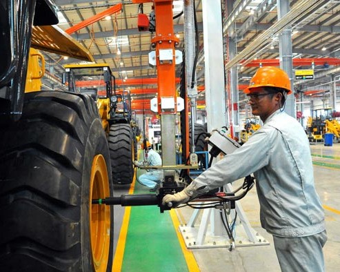 Workers assemble heavy equipment at a factory in Qingzhou, Shandong province. A preliminary reading of the Purchasing Managers' Index for the manufacturing industry edged down to 50.5 in December from 50.8 in November, the lowest level since October, HSBC Holdings Plc said in a report. [Photo / China Daily]