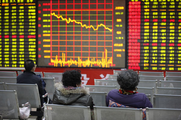 Investors track stock prices at a brokerage in Huaibei, Anhui province. State-owned enterprises took up 80 percent of the positions in the top 100 companies that suffered the most severely from falling share prices this year. [Photo / China Daily]