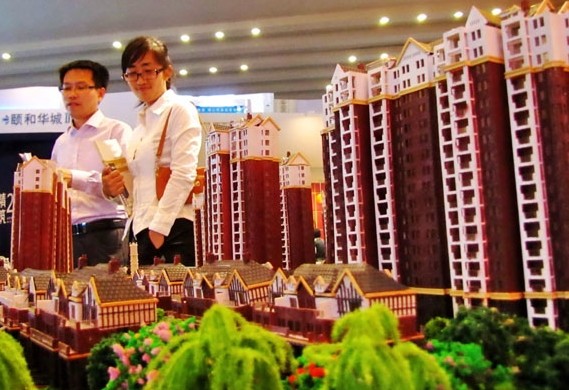 Residential property models are displayed at an expo in Shanghai. In first-tier and some second-tier cities, more tightening policies may be imposed in 2014, experts say. Provided to China Daily   