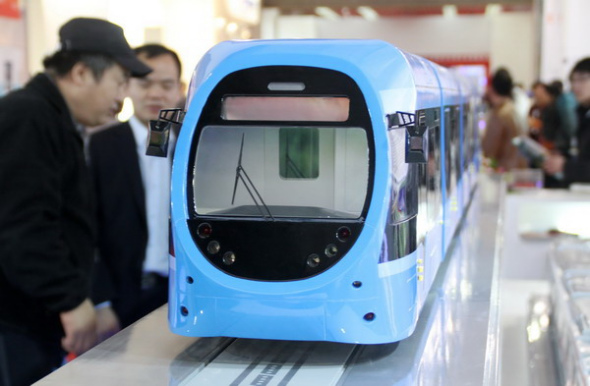 A tram car model developed by China CNR Corp Ltd is displayed at an expo in Beijing, Nov 19, 2013. The world's largest train maker by sales, raised $1.2 billion in a Hong Kong share offering, with pricing at the low end after a recent rally in its Shanghai-listed stock. [Photo by Wu Changqing / China Daily]