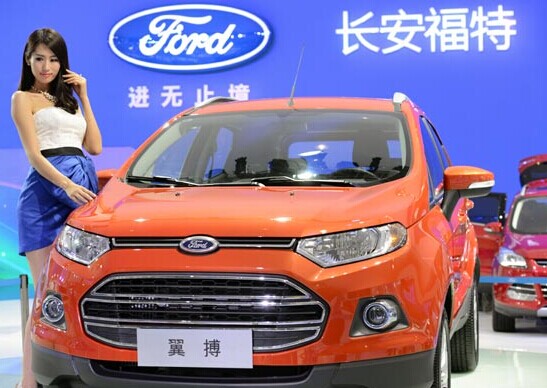 A model stands next to a Ford Motor Co vehicle at an auto show in Chongqing on June 6.The company's sales in China surged 32 percent year-on-year to 93,323 units in May. Provided to China Daily  