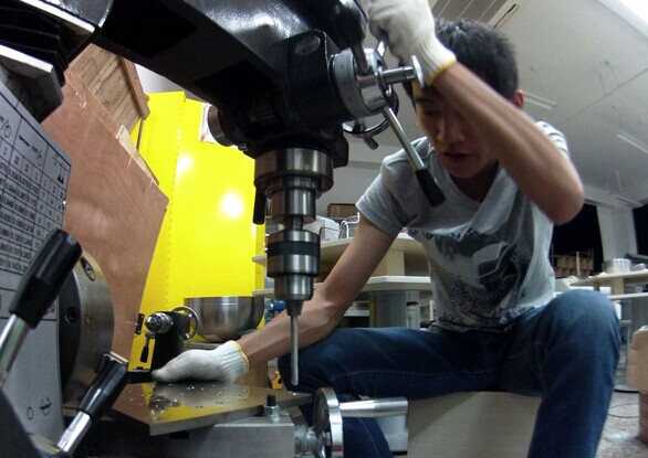 Wu Xiaofei, a machinery manufacturing specialist at Link Space in Shenzhen, works on the shaker table, part of the research equipment for the company's rocket launch project. PROVIDED TO CHINA DAILY  