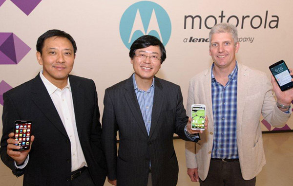 The new chairman of the Motorola management board Liu Jun (Left), and Yang Yuanqing (middle), chairman and CEO of Lenovo and Rick Osterloh, president and chief operating officer of Motorola hold Lenovo smartphones at a press conference in Beijing, Oct 30, 2014. [Provided to chinadaily.com.cn]  