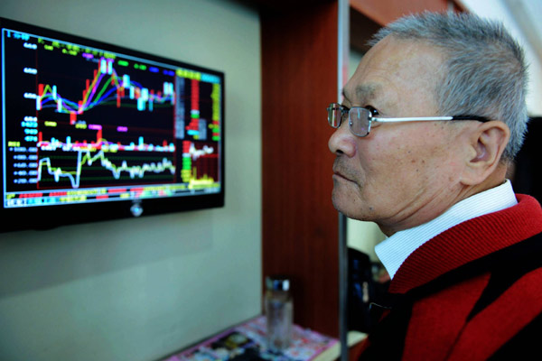 A customer checks share prices at a securities firm in Qingdao, Shandong province, on Nov 3, 2014. The widely anticipated through train stock program might have been delayed due to the illegal protests in Hong Kong, an official at a think tank said. [Yu Fangping / China Daily]   