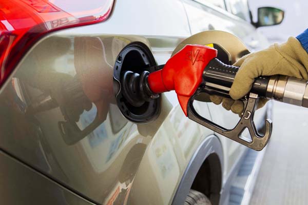 A worker fills up a car with fuel at a gas station in Lianyungang city, East China's Jiangsu province, Feb 9, 2015. [Photo/Xinhua]