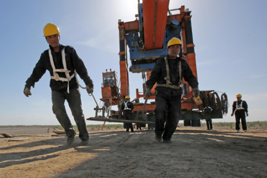 Workers prepare for the construction of a bridge over the Ejina-Hami railway in the Xinjiang Uygur autonomous region last week. (Photo/China Daily)