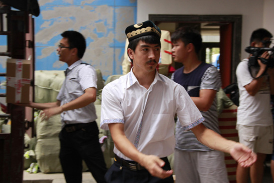 Adil Mamattura, the 24-yearold chairman of the board of Hunan Mengxiang Qihang E-commerce Co Ltd, works together with his colleagues in a warehouse. (Photo provided to China Daily)